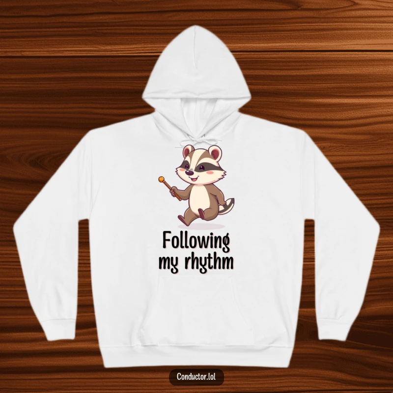 Funny and cozy hoodie depicting a cheerful badger with a baton, energetically tapping its foot and smiling, radiating happy leadership.